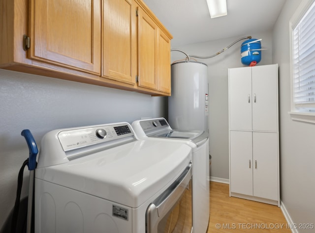 clothes washing area featuring cabinets, washing machine and dryer, water heater, and light wood-type flooring