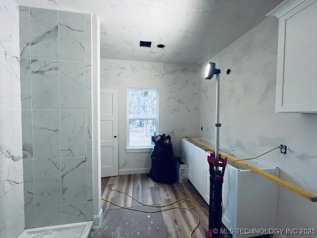 bathroom with hardwood / wood-style flooring and a shower