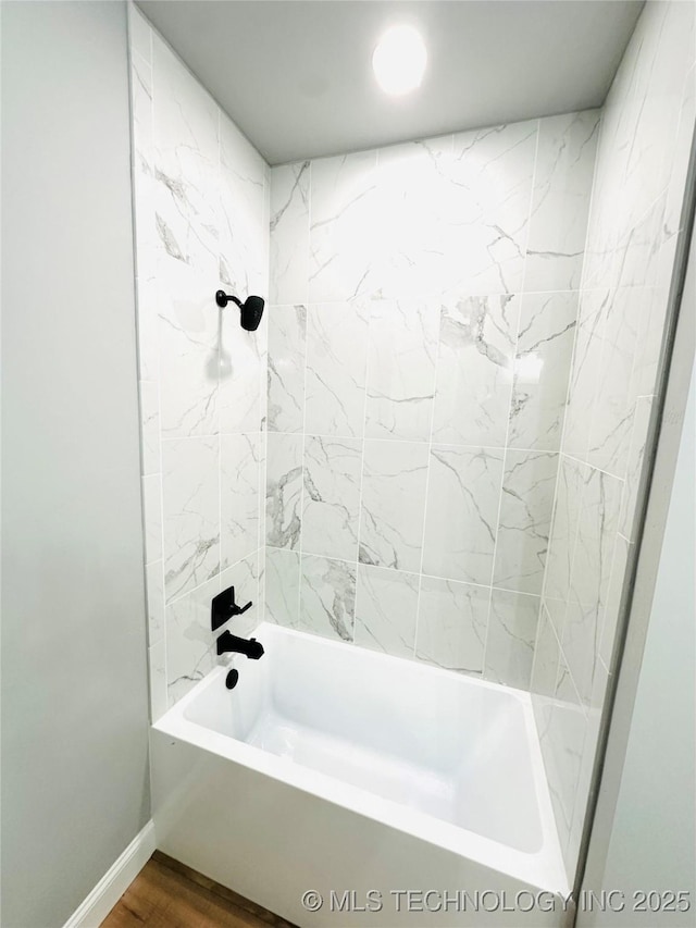 bathroom with shower / bath combination, baseboards, and wood finished floors