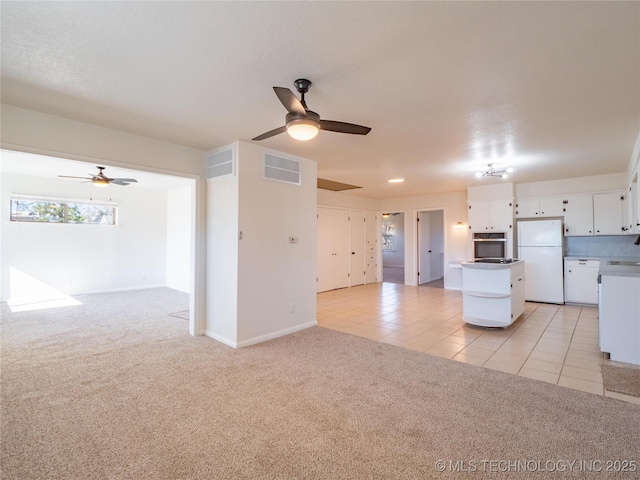 kitchen with white cabinetry, oven, white fridge, ceiling fan, and light carpet