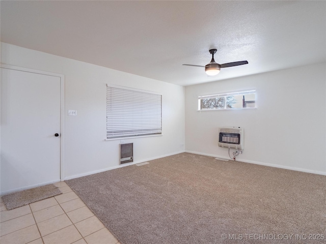 tiled empty room with ceiling fan and heating unit