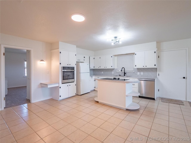 kitchen featuring white cabinetry, stainless steel appliances, decorative backsplash, and light tile patterned floors