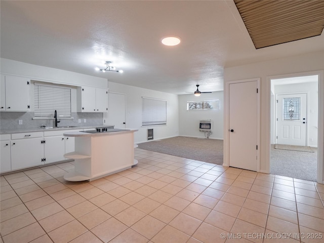 kitchen with tasteful backsplash, white cabinetry, sink, light tile patterned floors, and ceiling fan