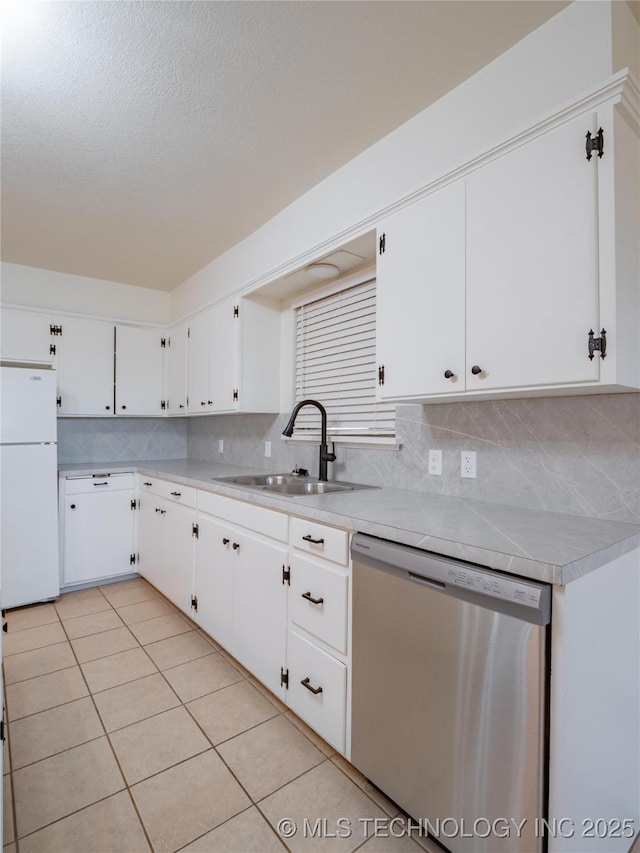 kitchen with sink, white cabinets, white fridge, stainless steel dishwasher, and light tile patterned floors