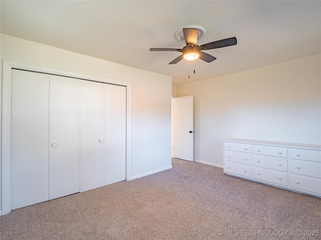 unfurnished bedroom featuring light carpet, a closet, and ceiling fan