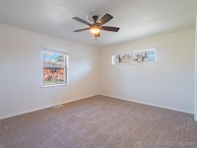 carpeted spare room featuring ceiling fan