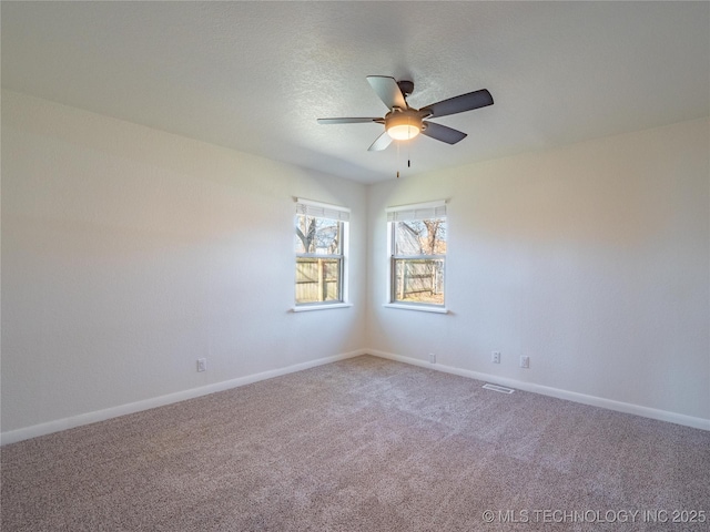 carpeted spare room with a textured ceiling and ceiling fan