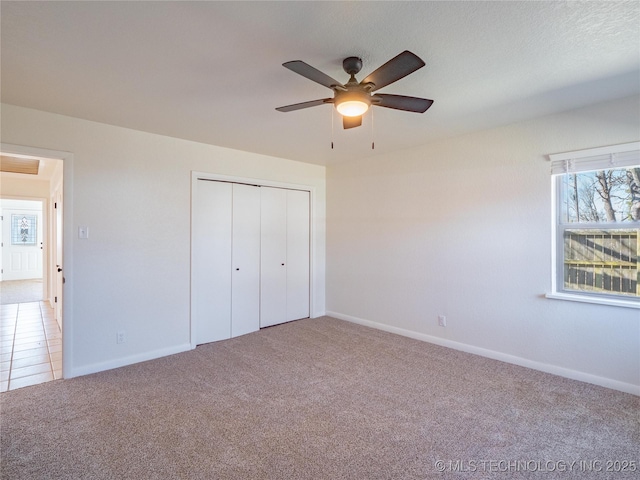 unfurnished bedroom with a closet, ceiling fan, and carpet flooring