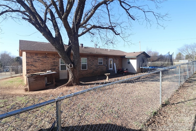 rear view of property with a trampoline