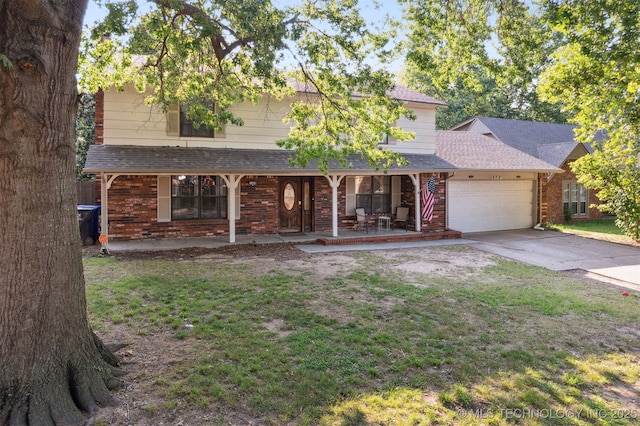 view of front facade featuring a garage, a front yard, and covered porch