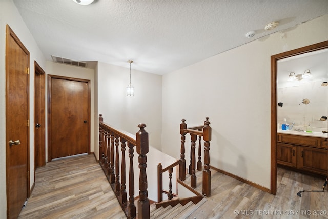 hallway featuring a textured ceiling and light wood-type flooring