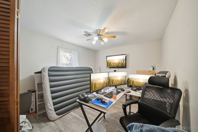 interior space featuring a textured ceiling, ceiling fan, and light wood-type flooring