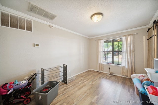 miscellaneous room with hardwood / wood-style flooring, crown molding, and a textured ceiling