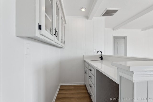 interior space featuring hardwood / wood-style flooring, beam ceiling, sink, and crown molding