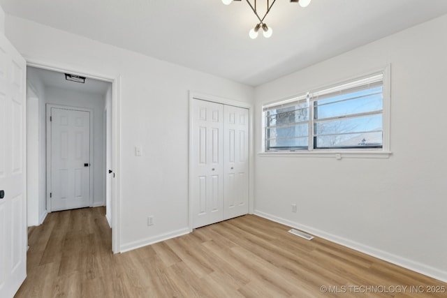 unfurnished bedroom with a closet and light wood-type flooring