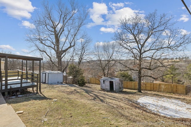 view of yard featuring a wooden deck and a storage unit