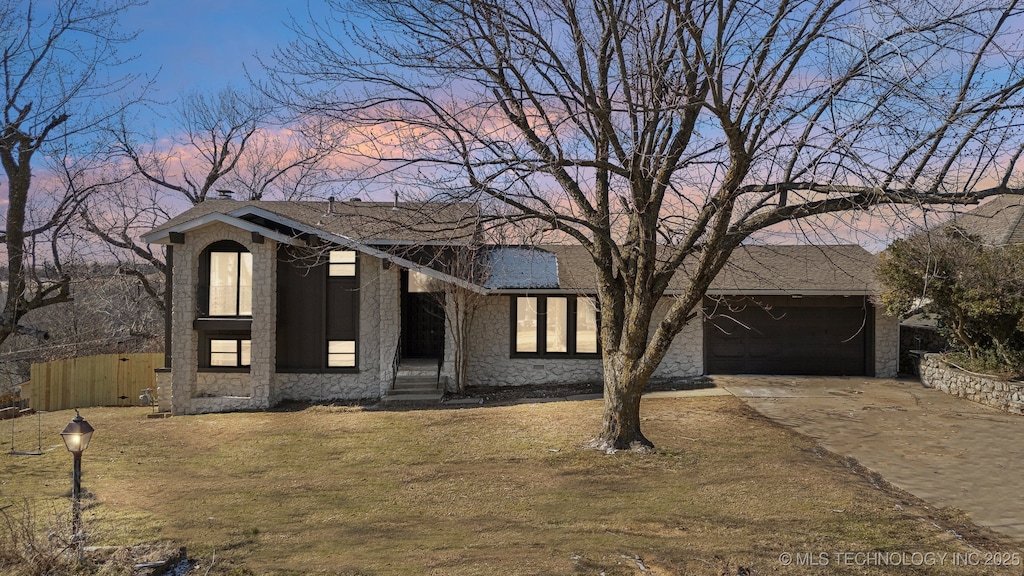 view of front of home with a garage and a yard