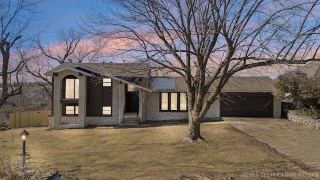 view of front of home with a garage and a yard