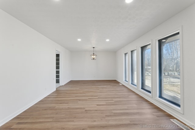 spare room featuring a wealth of natural light and light wood-type flooring