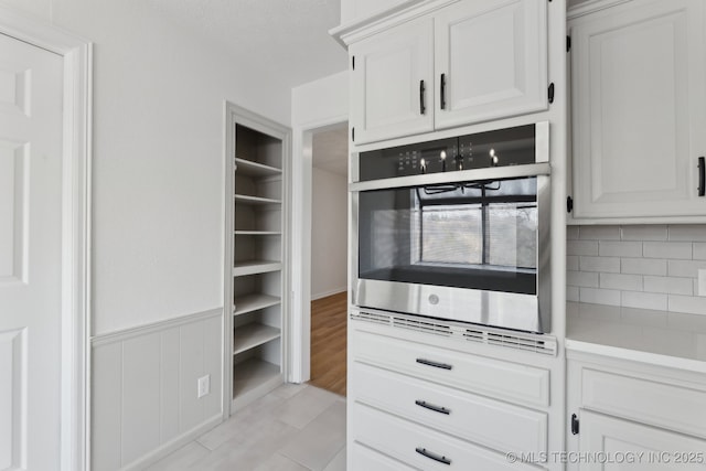 kitchen featuring white cabinetry and oven