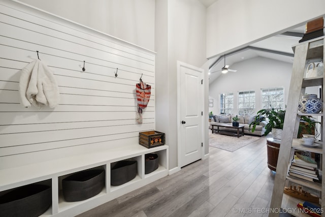 mudroom with wood-type flooring, high vaulted ceiling, and ceiling fan