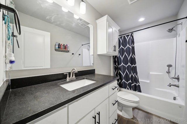 full bathroom featuring vanity, hardwood / wood-style floors, toilet, and shower / bath combo with shower curtain