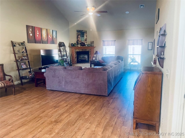 living room featuring vaulted ceiling, ceiling fan, and light hardwood / wood-style flooring