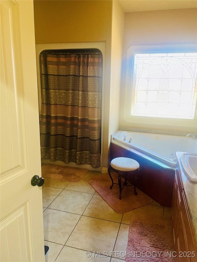 bathroom with tile patterned floors, a bathtub, and vanity