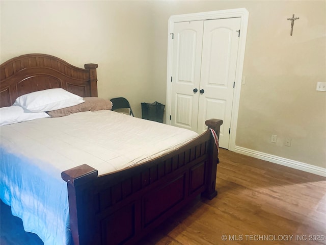 bedroom featuring dark hardwood / wood-style floors and a closet