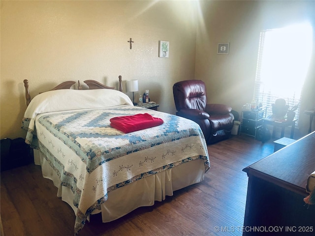 bedroom with dark hardwood / wood-style flooring