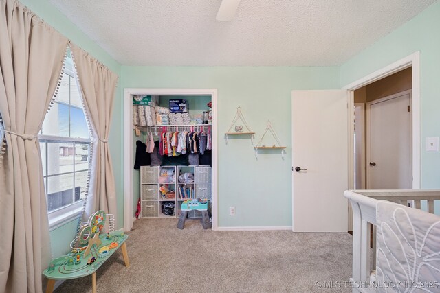 clothes washing area featuring a wood stove, cabinets, light tile patterned floors, ceiling fan, and a textured ceiling