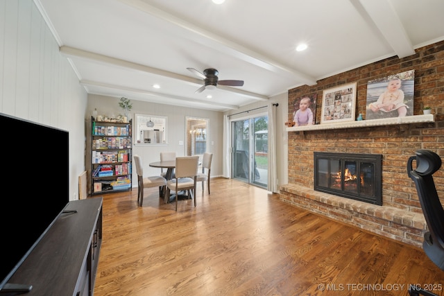 dining space with beamed ceiling, a ceiling fan, recessed lighting, a fireplace, and light wood finished floors