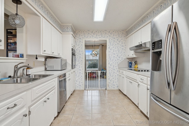 kitchen featuring wallpapered walls, a sink, black appliances, light countertops, and under cabinet range hood