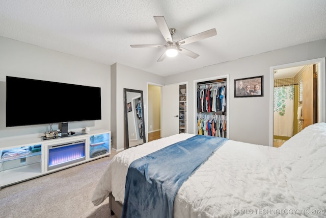 bedroom with carpet flooring, ensuite bathroom, a closet, a textured ceiling, and a ceiling fan