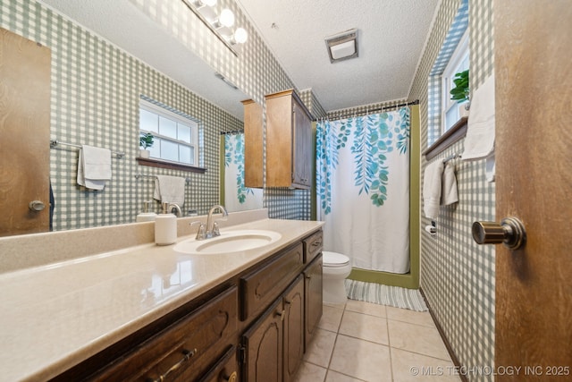 bathroom with tile patterned flooring, wallpapered walls, toilet, vanity, and a textured ceiling