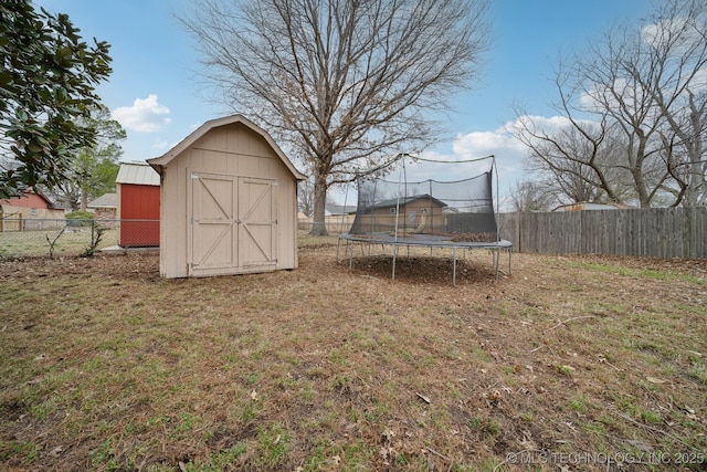 view of shed with a fenced backyard and a trampoline