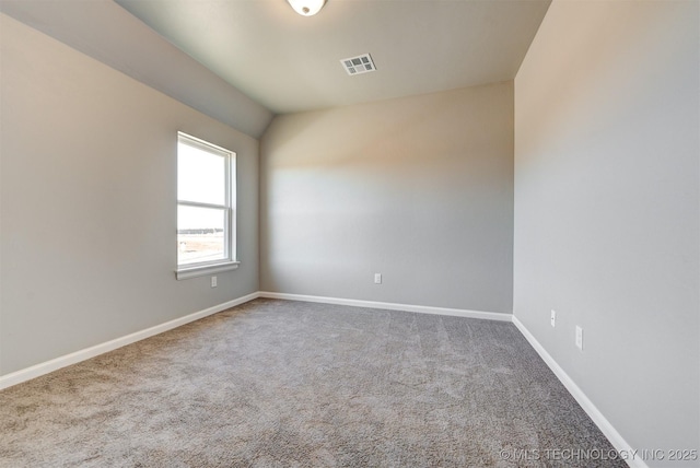 empty room featuring lofted ceiling and carpet floors