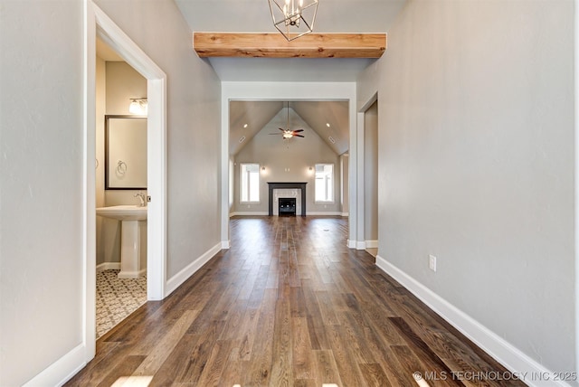 corridor featuring dark hardwood / wood-style flooring and vaulted ceiling with beams