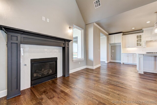 unfurnished living room with lofted ceiling and dark wood-type flooring