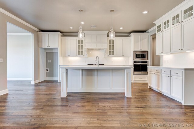 kitchen featuring a kitchen island with sink, crown molding, white cabinets, and appliances with stainless steel finishes