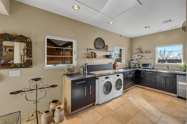 laundry room featuring sink, washer and clothes dryer, and light tile patterned flooring