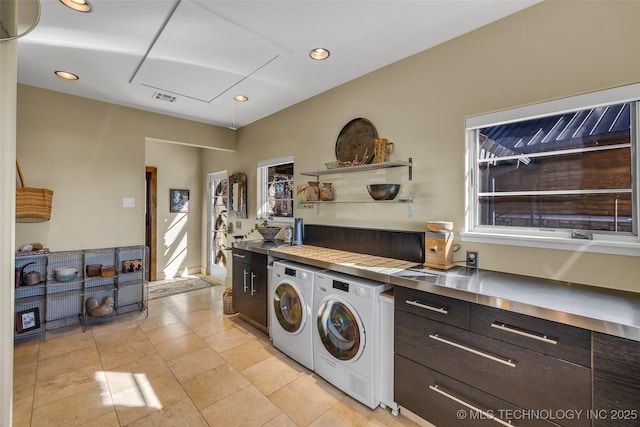 laundry area featuring washer and clothes dryer, light tile patterned floors, and plenty of natural light