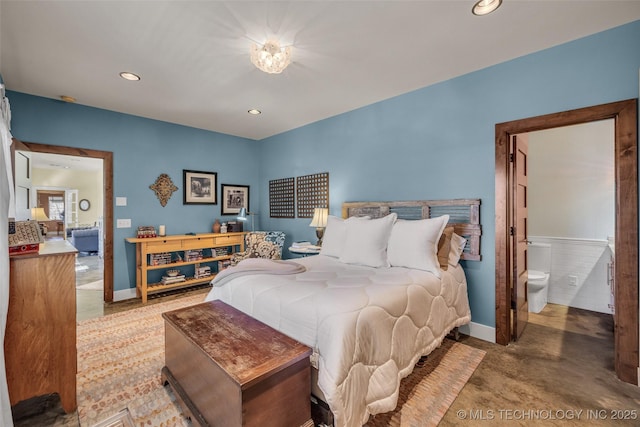 bedroom featuring connected bathroom and concrete flooring