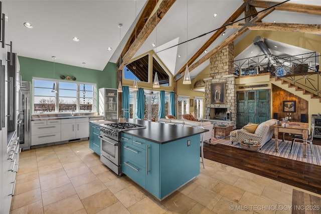 kitchen featuring high end stainless steel range oven, high vaulted ceiling, blue cabinets, decorative light fixtures, and beamed ceiling