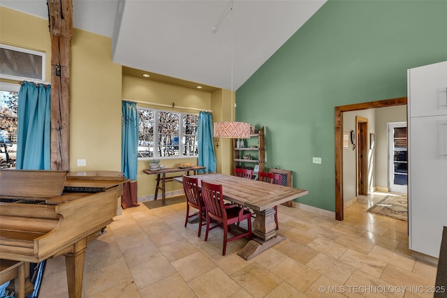 dining area featuring high vaulted ceiling