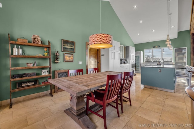 dining space with high vaulted ceiling