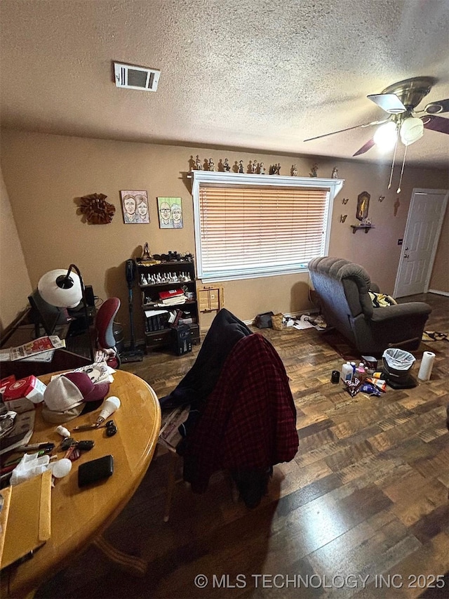 bedroom featuring dark wood-type flooring, a textured ceiling, and ceiling fan