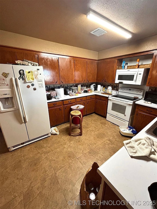 kitchen with white appliances and a textured ceiling