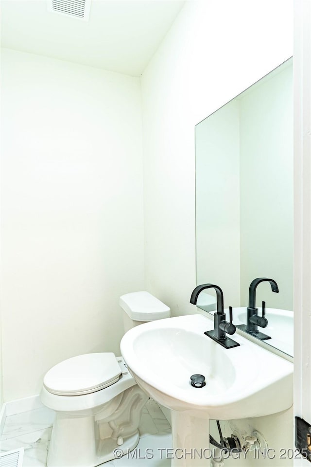 bathroom featuring toilet and sink