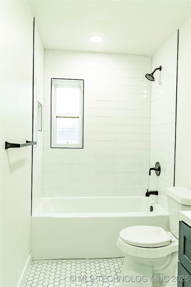 full bathroom with tiled shower / bath combo, vanity, tile patterned floors, and toilet